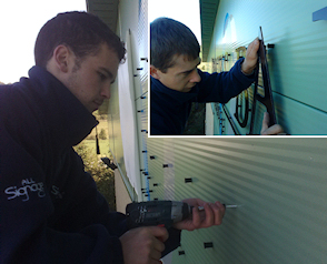 Flat cut acrylic lettering being fixed directly onto a metal cladded industrial unit.